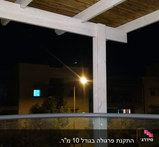 פרגולה מעץ עם קורות במרפסת בלילה